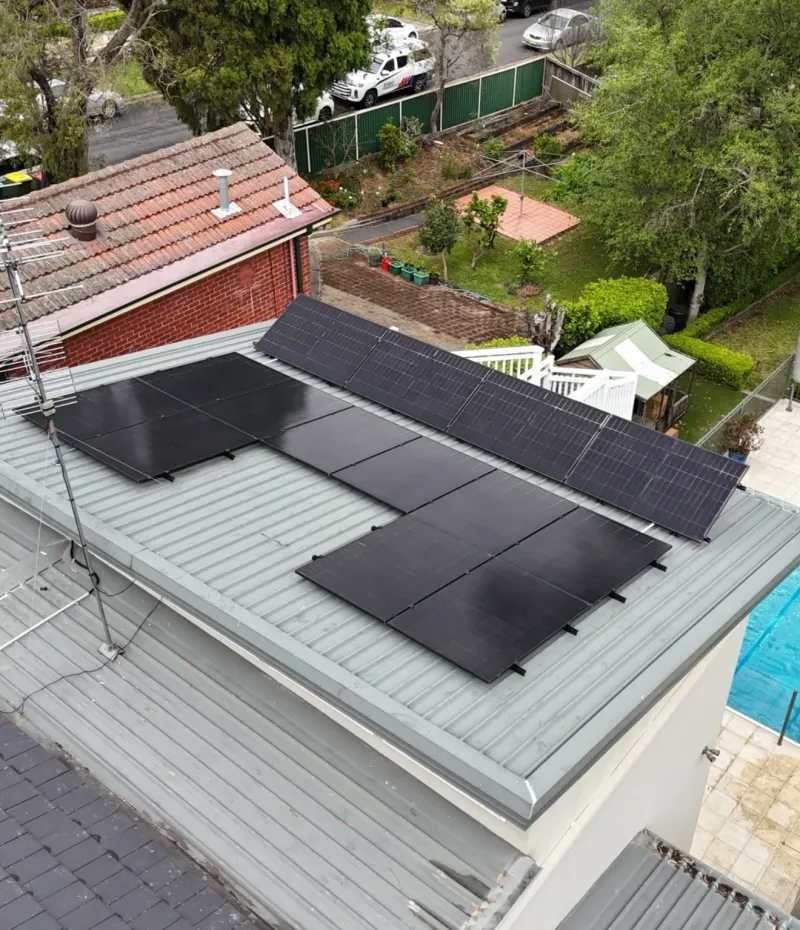 Aerial view of black solar panels on a metal roof