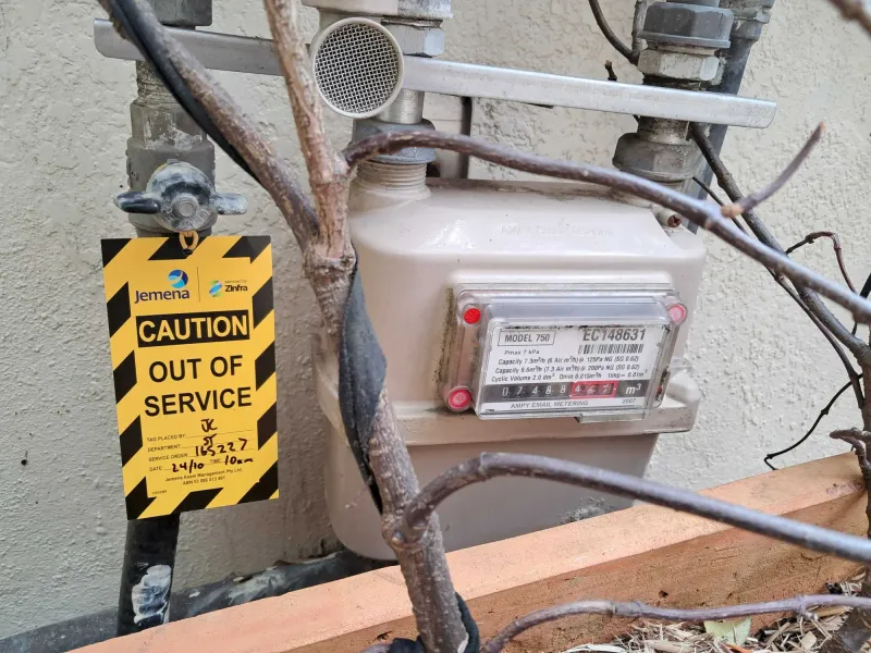 A gas meter with a yellow Out of Service tag