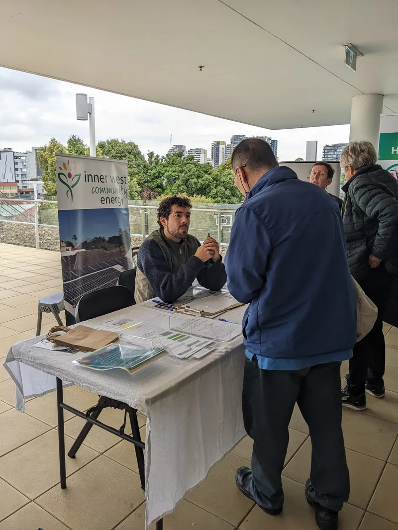 A volunteer talking with a visitor at an Inner West Community Energy stall