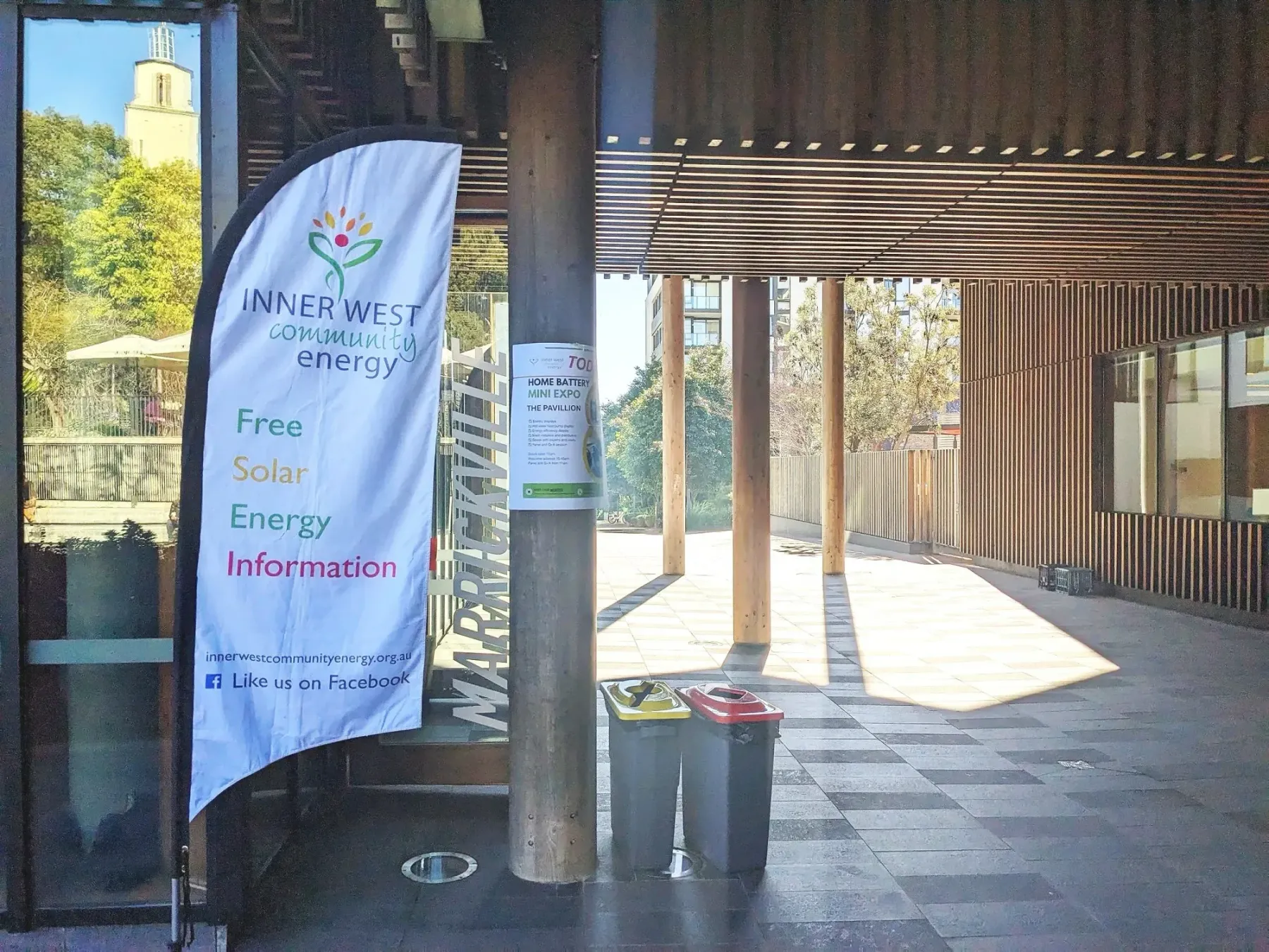 An IWCE banner stands in a sunlit outdoor corridor at Marrickville Pavilion.